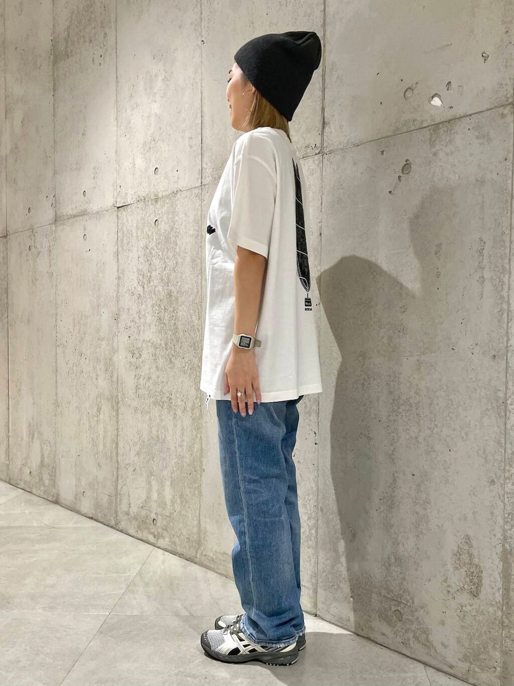 ブルー系のデニムパンツ、ブラック系のタンクトップ、ベージュ系のショルダーバッグを着用したレディースの春コーディネートの8枚目の写真