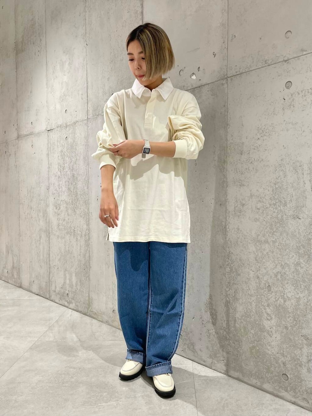 ベージュ系のショルダーバッグ、ホワイト系のローファー、ベージュ系のポロシャツを着用したレディースの夏コーディネートの5枚目の写真