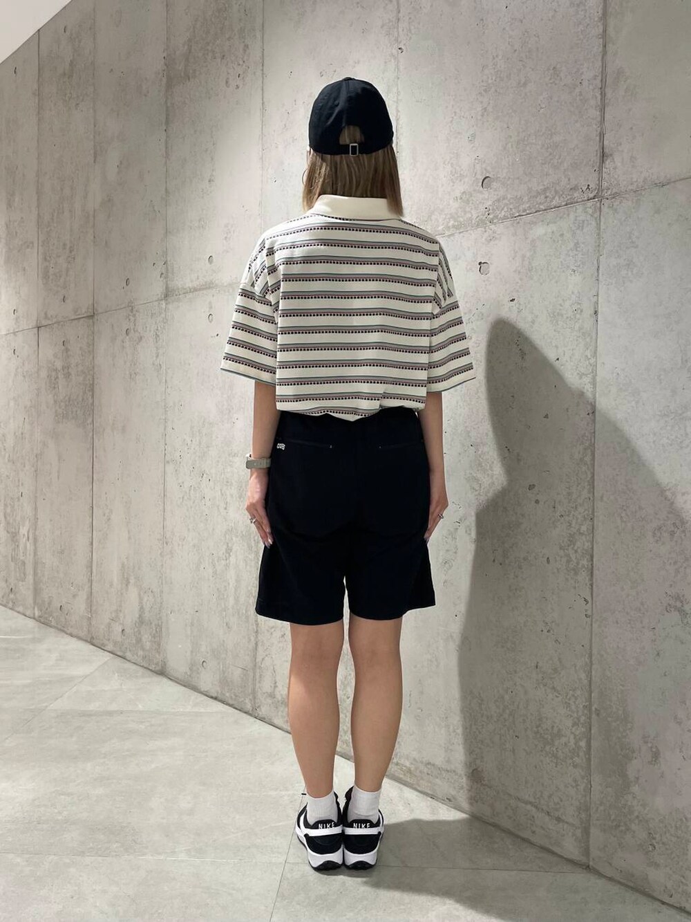 ブラック系のスニーカー、ブラック系のその他パンツ、ホワイト系のTシャツ/カットソーを着用したレディースの春コーディネートの3枚目の写真