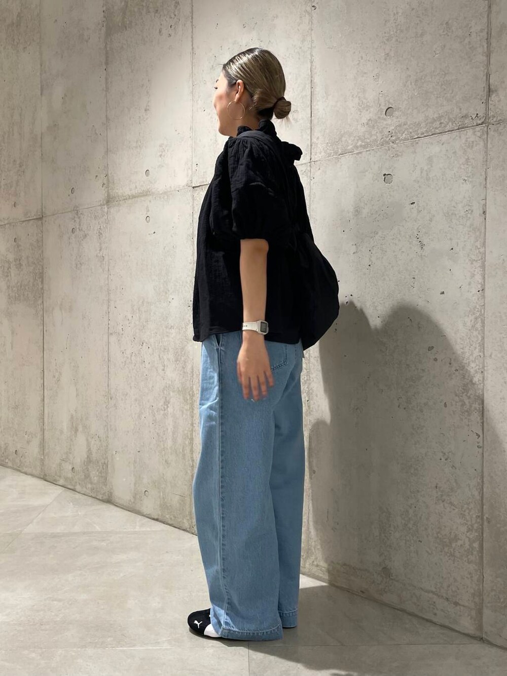 ブルー系のデニムパンツ、ブラック系のショルダーバッグ、ブラック系のシャツ/ブラウスを着用したレディースの夏コーディネートの2枚目の写真