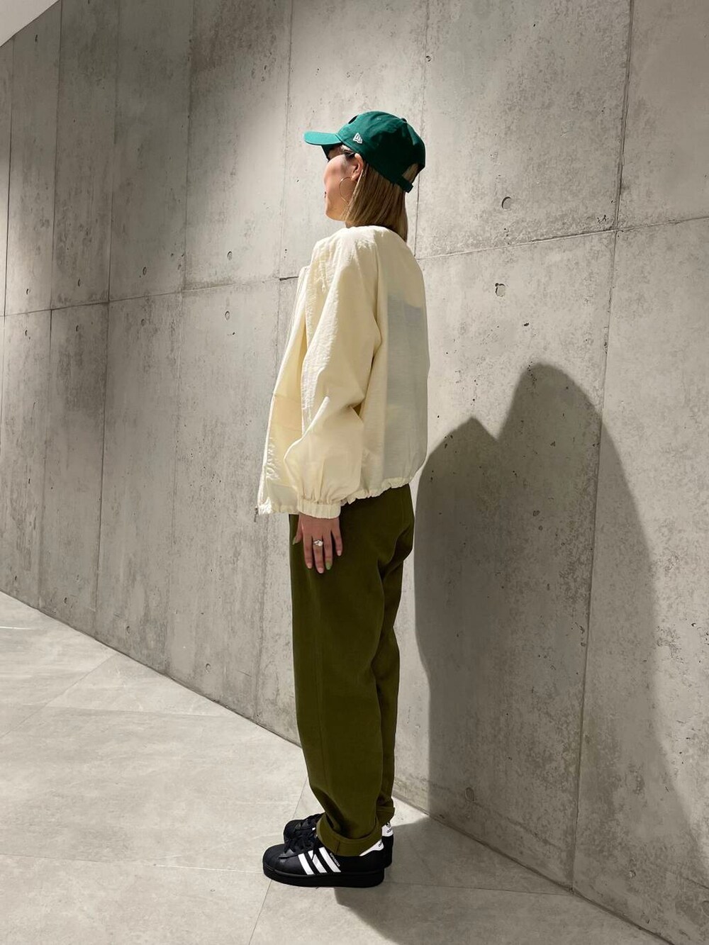 ホワイト系のブルゾン、ブラック系のスニーカー、イエロー系のTシャツ/カットソーを着用したレディースの春コーディネートの2枚目の写真