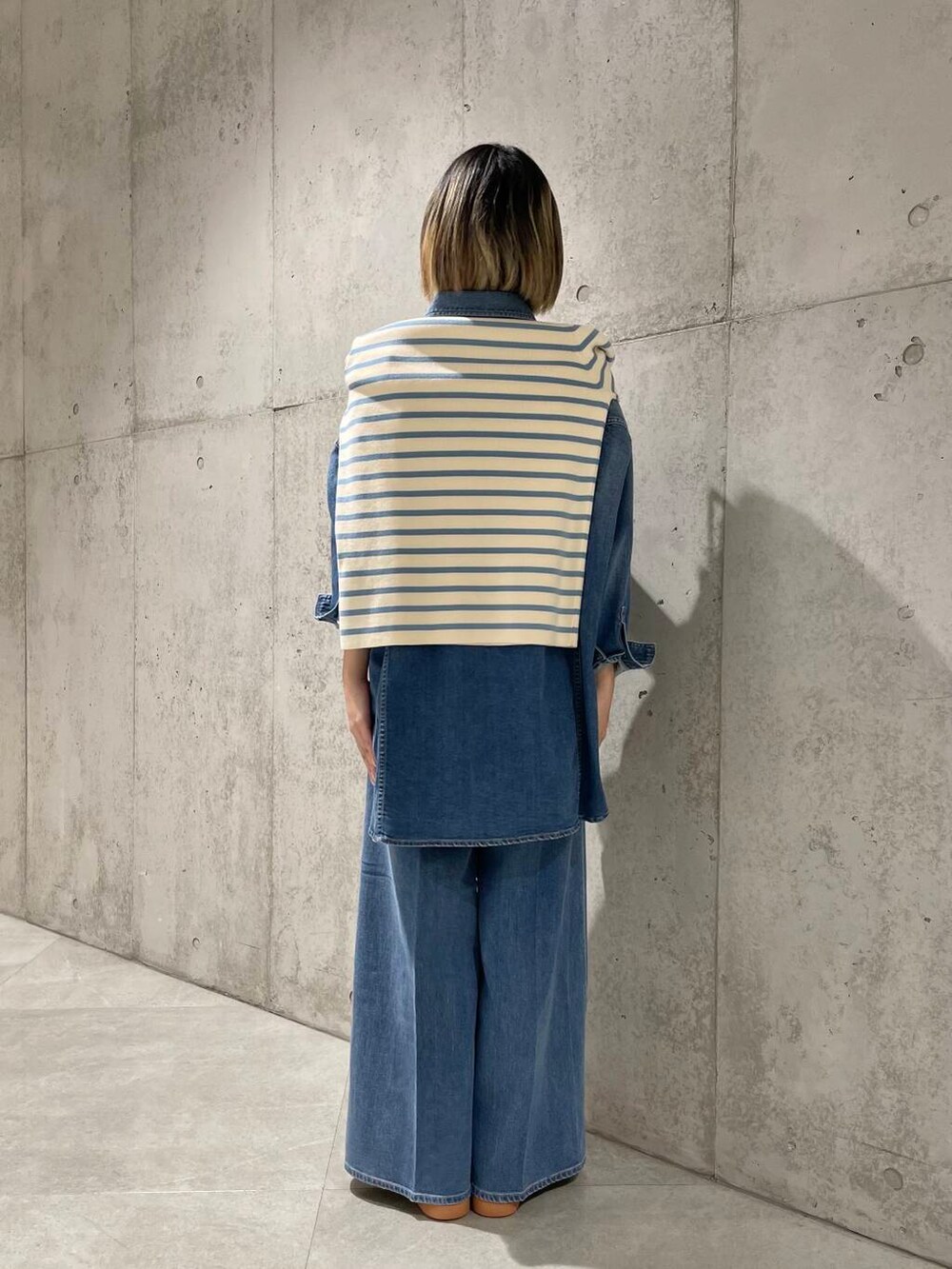 ブルー系のデニムパンツ、ブルー系のニット/セーター、ブルー系のシャツ/ブラウスを着用したレディースの冬コーディネートの4枚目の写真