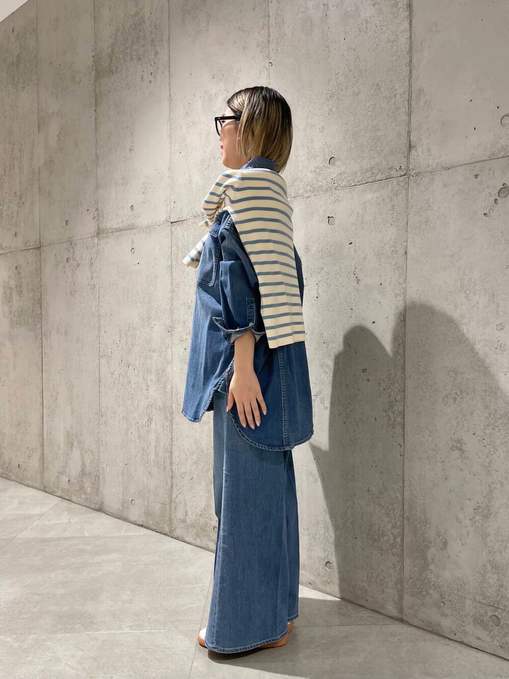 ブルー系のデニムパンツ、ブルー系のニット/セーター、ブルー系のシャツ/ブラウスを着用したレディースの冬コーディネートの3枚目の写真