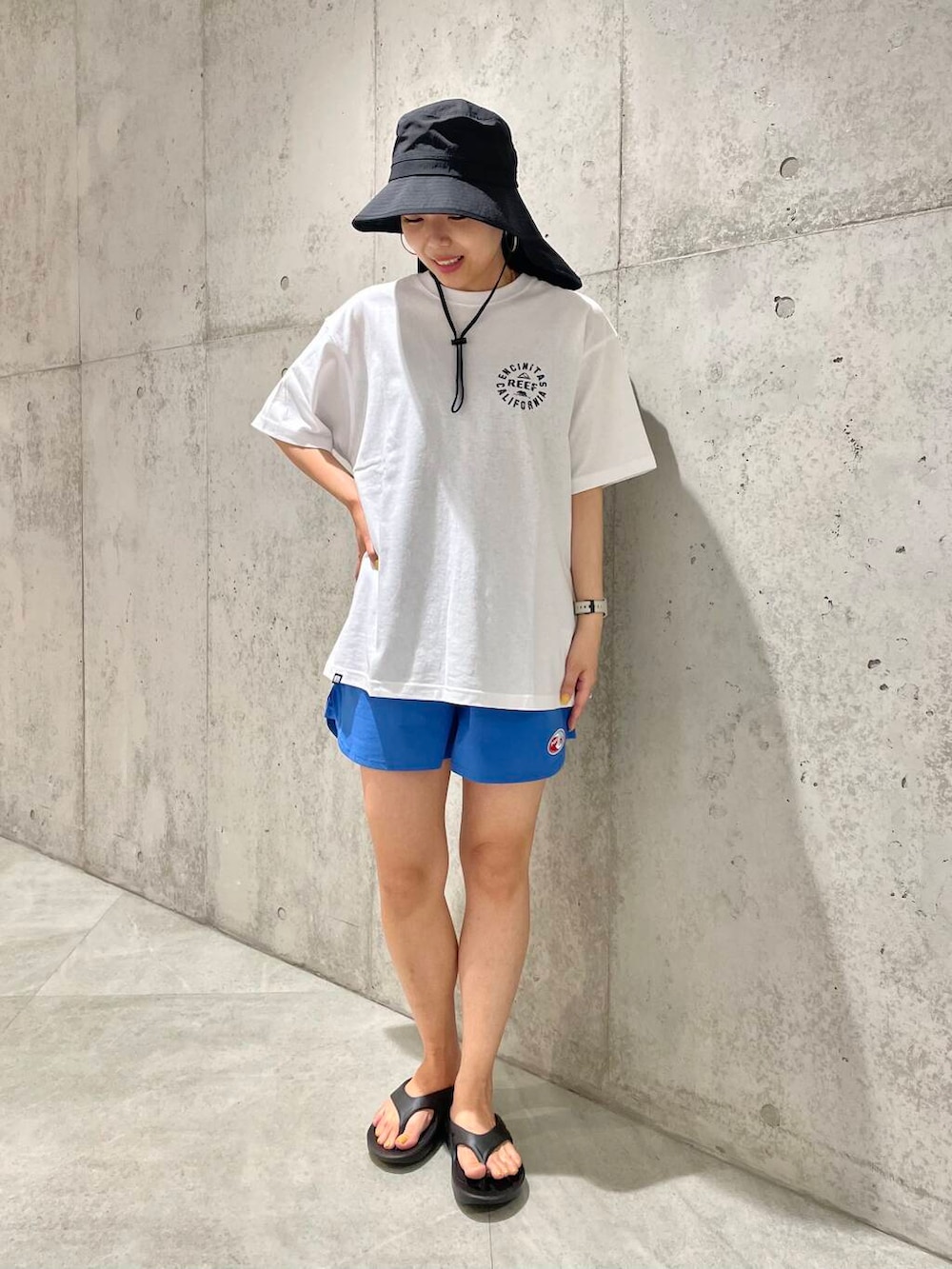 ブラック系のサンダル、ホワイト系のTシャツ/カットソー、ブルー系のその他パンツを着用したレディースの夏コーディネートの2枚目の写真