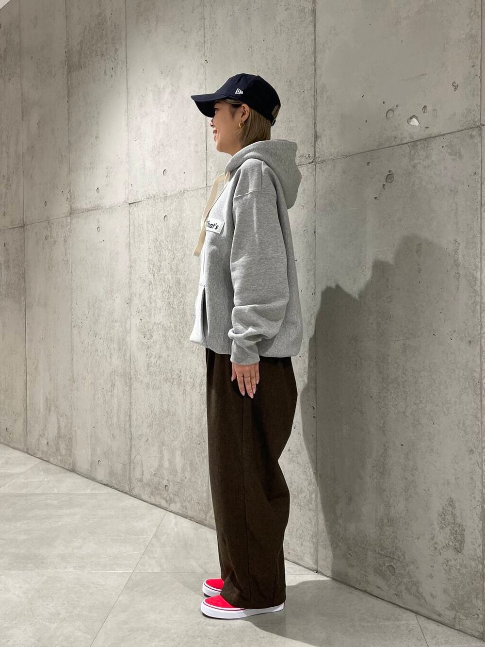 グレー系のパーカー、ブラウン系のその他パンツ、レッド系のスニーカーを着用したレディースの冬コーディネートの2枚目の写真