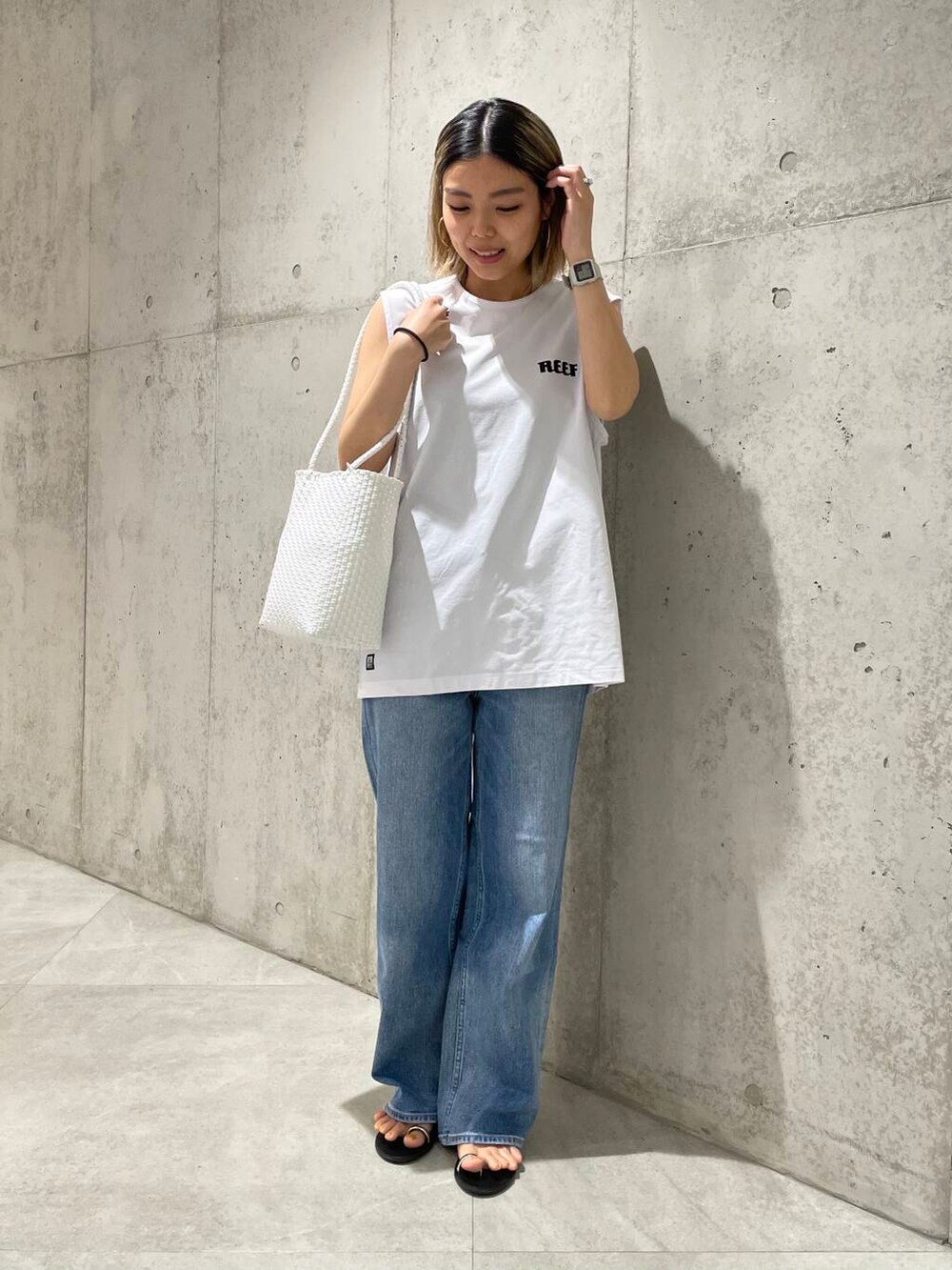 ブルー系のデニムパンツ、ホワイト系のTシャツ/カットソー、ホワイト系のタンクトップを着用したレディースの春コーディネートの4枚目の写真