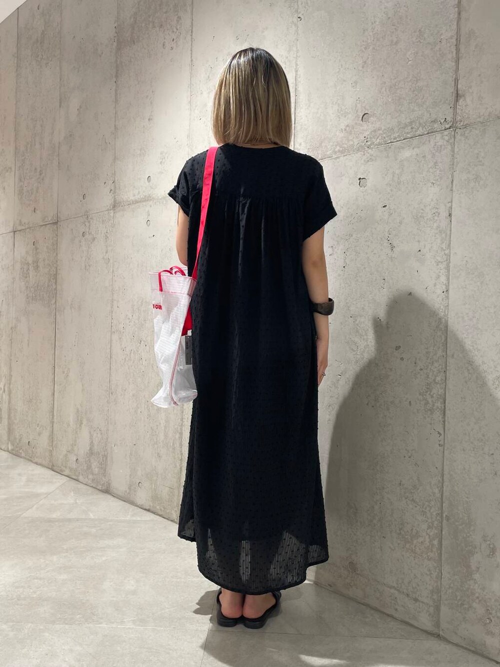 ホワイト系のトートバッグ、ブラック系のワンピースを着用したレディースの春コーディネートの3枚目の写真