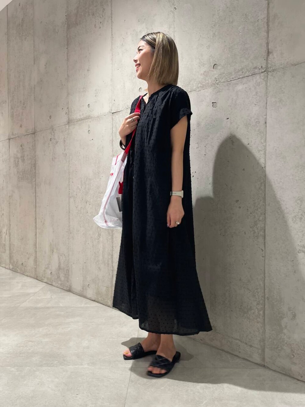 ホワイト系のトートバッグ、ブラック系のワンピースを着用したレディースの春コーディネートの2枚目の写真