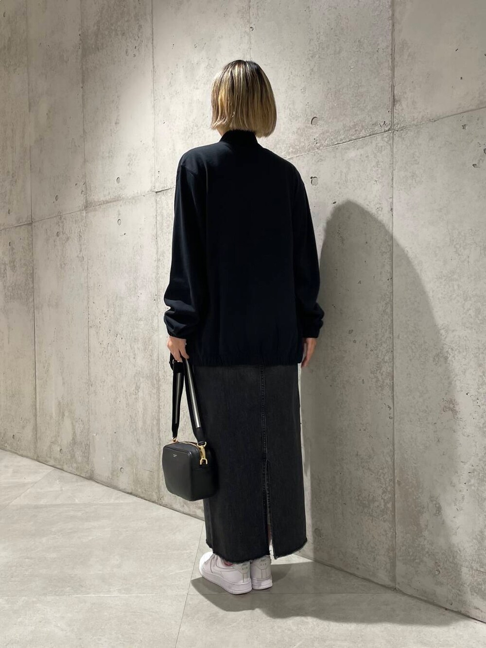 ブラック系のその他アウター、ブラック系のショルダーバッグ、ホワイト系のTシャツ/カットソーを着用したレディースの秋コーディネートの3枚目の写真