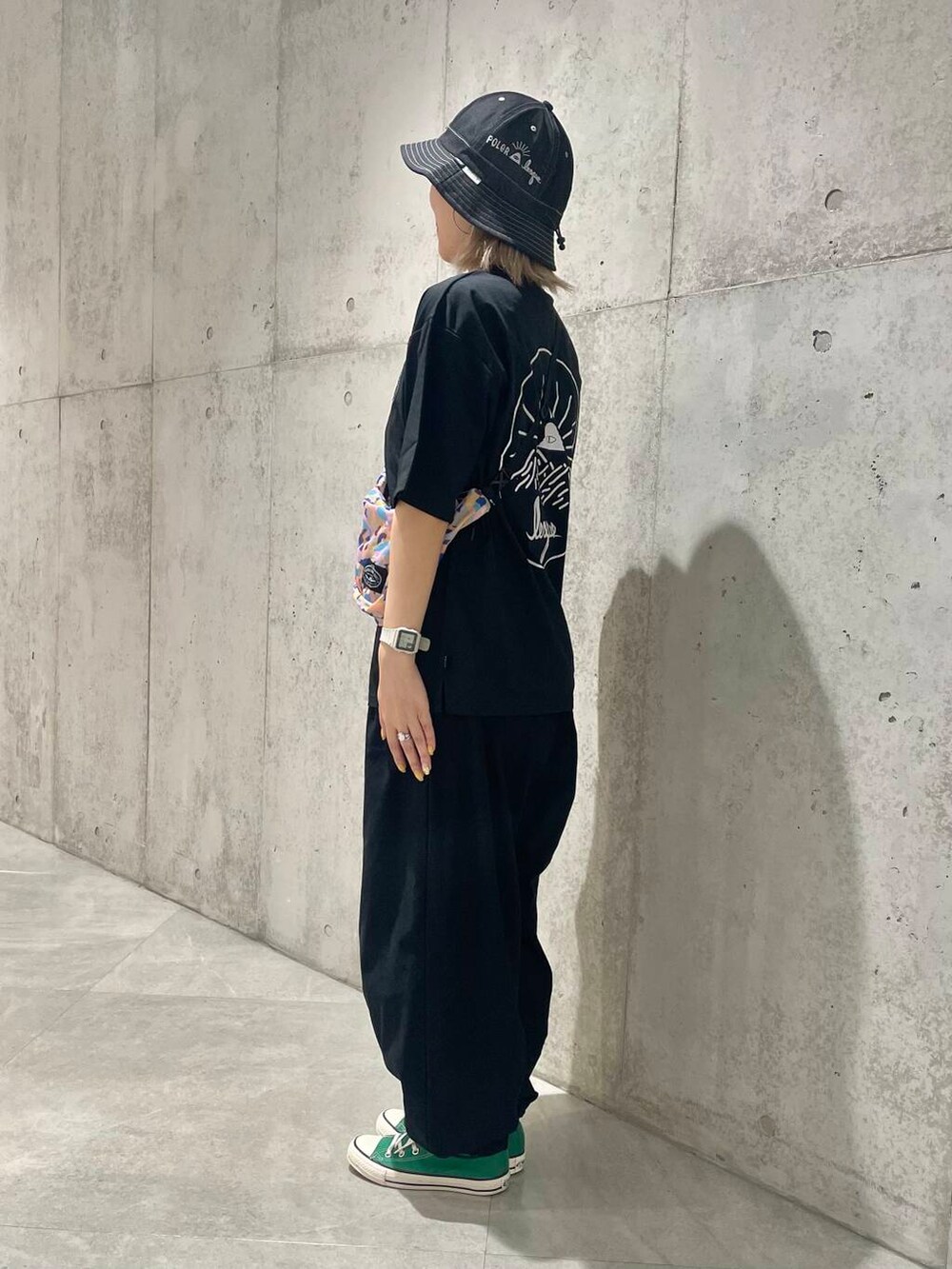 ブルー系のショルダーバッグ、ブラック系のTシャツ/カットソー、ブラック系のハットを着用したレディースの夏コーディネートの2枚目の写真