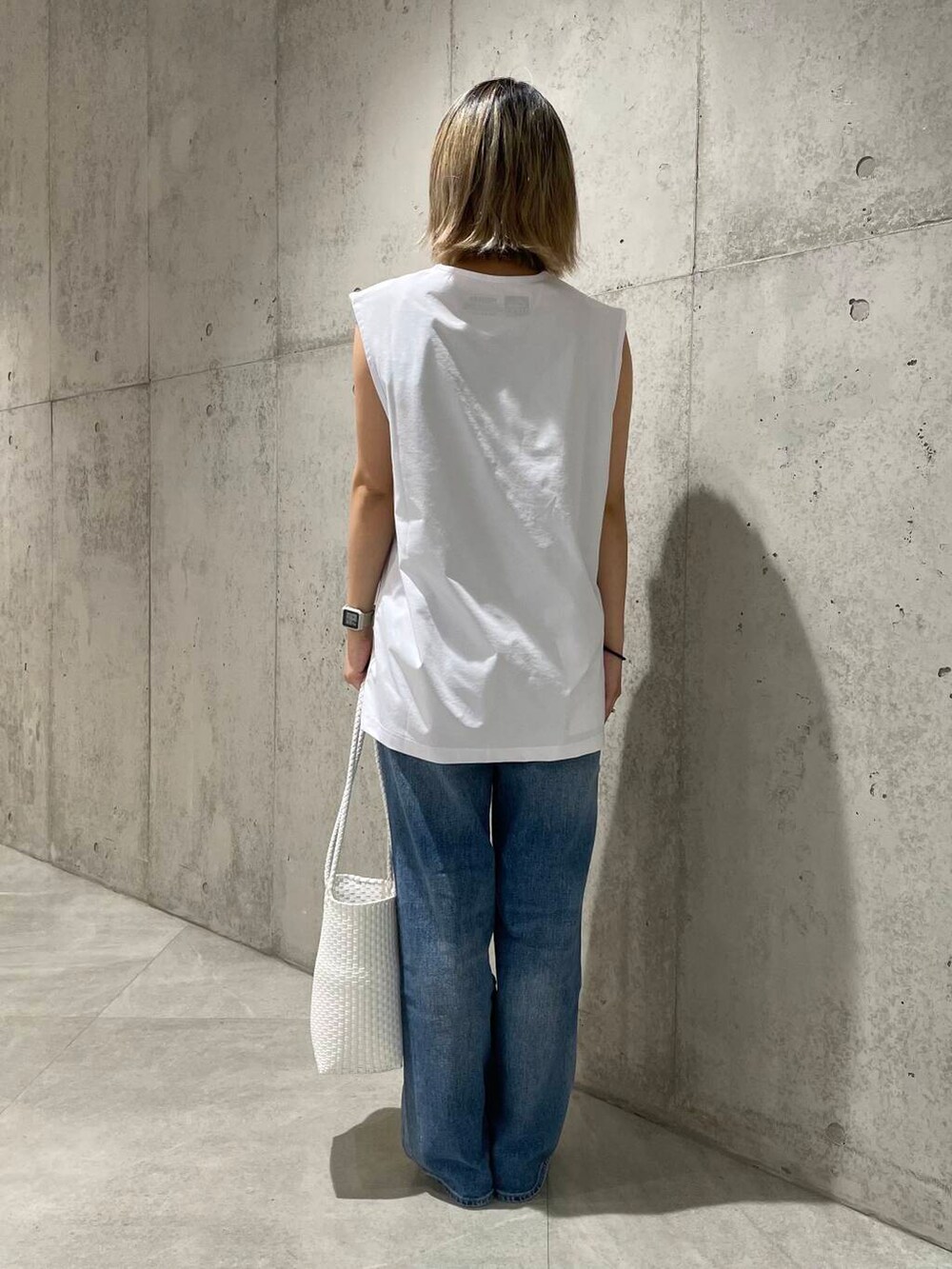 ブルー系のデニムパンツ、ホワイト系のTシャツ/カットソー、ホワイト系のタンクトップを着用したレディースの春コーディネートの2枚目の写真