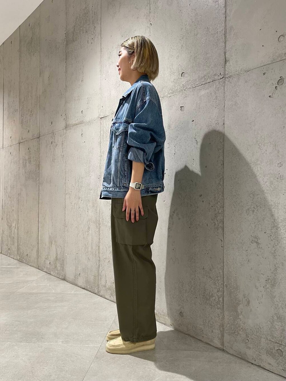 ベージュ系のローファー、グリーン系のカーゴパンツ、ブルー系のデニムジャケットを着用したレディースの夏コーディネートの2枚目の写真