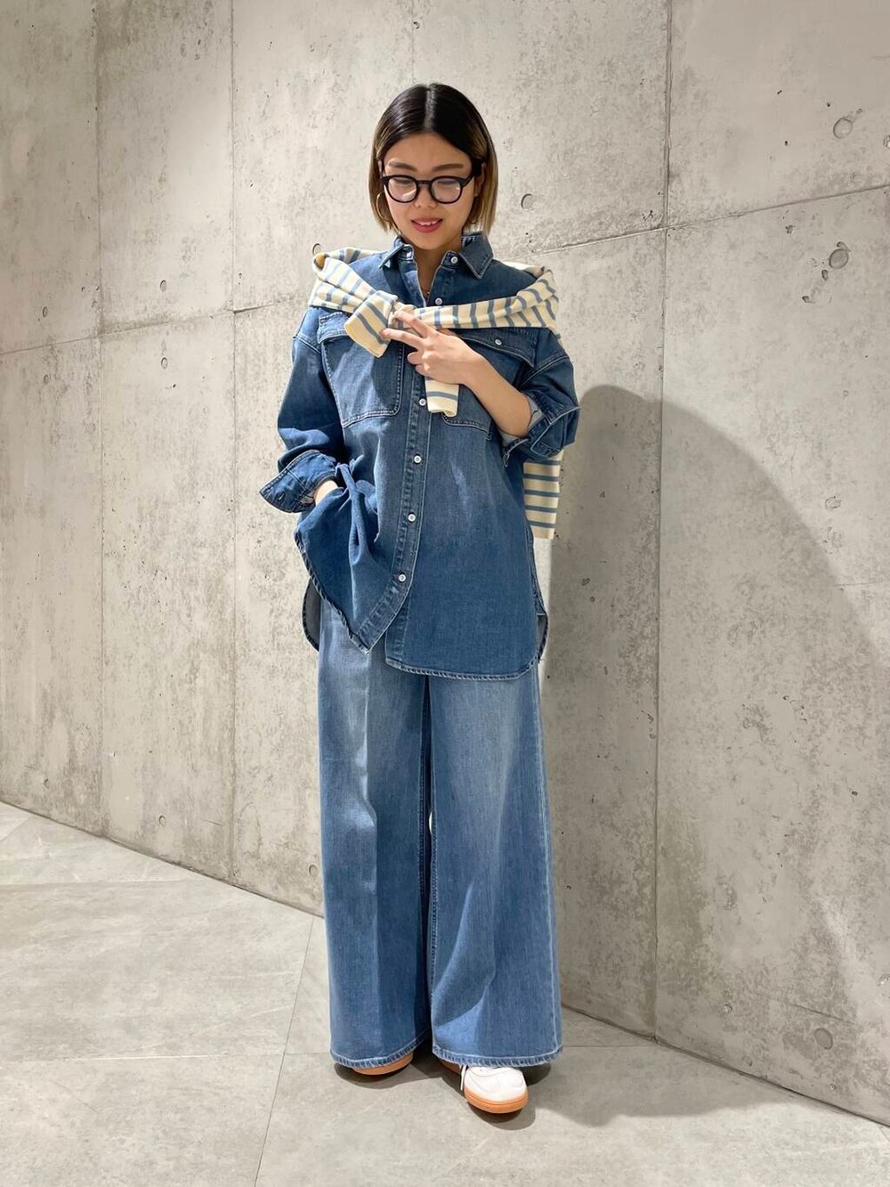 ブルー系のデニムパンツ、ブルー系のニット/セーター、ブルー系のシャツ/ブラウスを着用したレディースの冬コーディネートの2枚目の写真