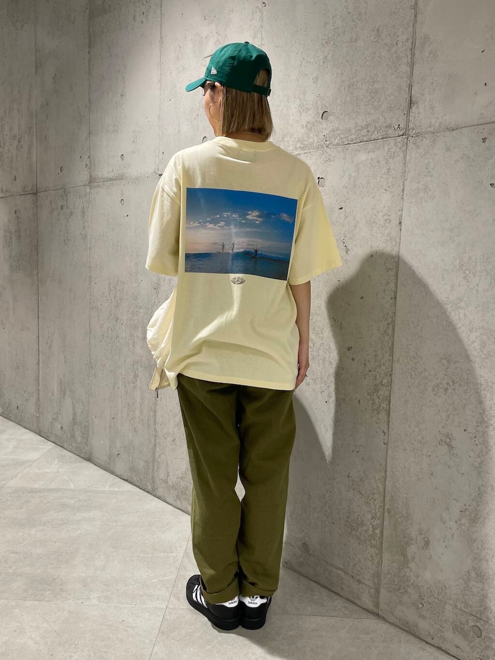ホワイト系のブルゾン、ブラック系のスニーカー、イエロー系のTシャツ/カットソーを着用したレディースの春コーディネートの4枚目の写真