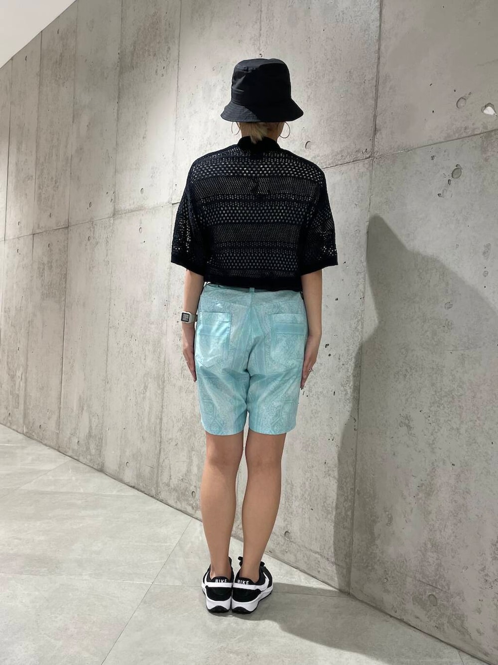 ブラック系のスニーカー、ブルー系のその他パンツ、ブラック系のポロシャツを着用したレディースの春コーディネートの3枚目の写真