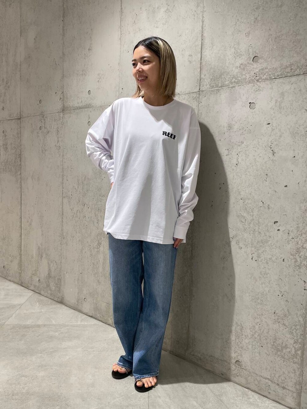 ブルー系のデニムパンツ、ホワイト系のTシャツ/カットソー、ホワイト系のタンクトップを着用したレディースの春コーディネートの5枚目の写真