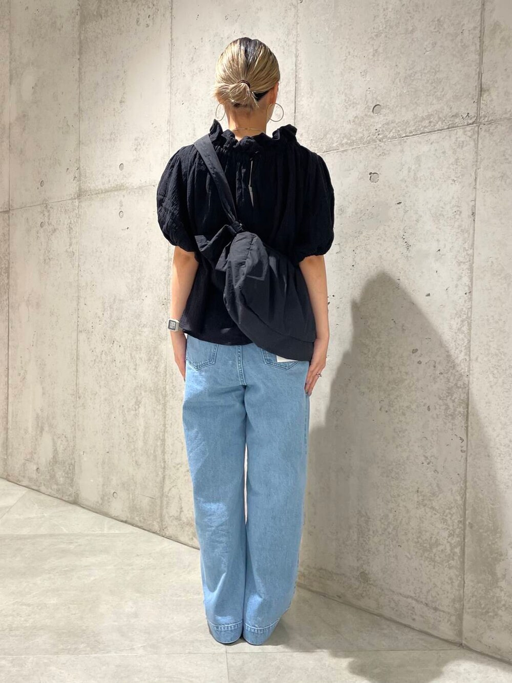 ブルー系のデニムパンツ、ブラック系のショルダーバッグ、ブラック系のシャツ/ブラウスを着用したレディースの夏コーディネートの3枚目の写真