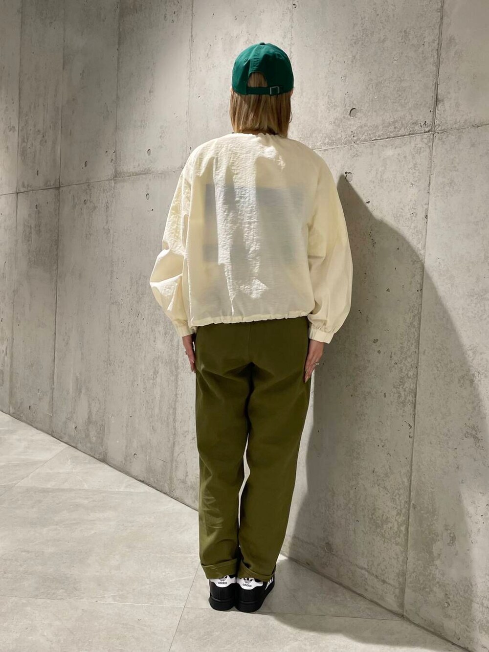 ホワイト系のブルゾン、ブラック系のスニーカー、イエロー系のTシャツ/カットソーを着用したレディースの春コーディネートの3枚目の写真