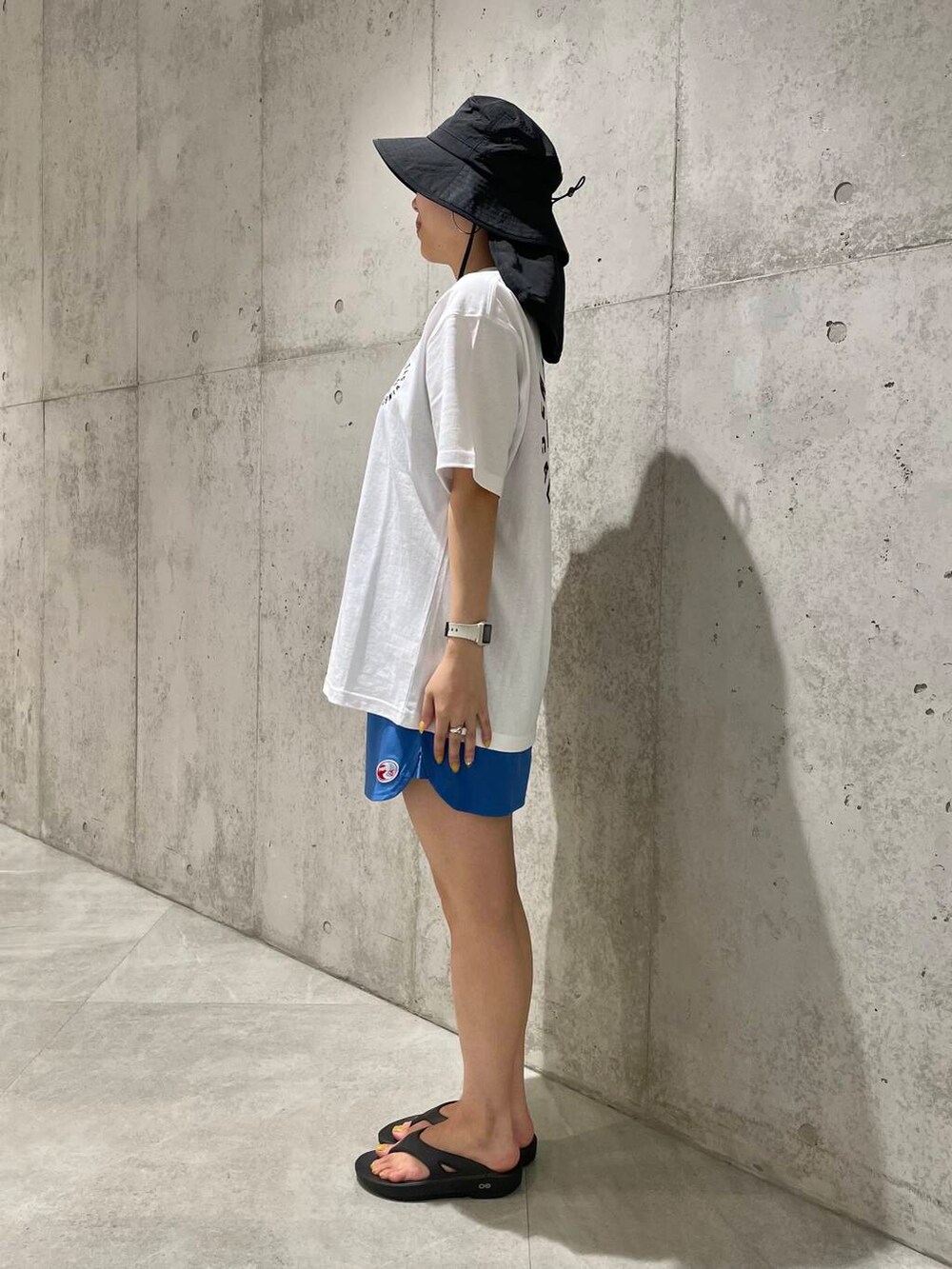 ブラック系のサンダル、ホワイト系のTシャツ/カットソー、ブルー系のその他パンツを着用したレディースの夏コーディネートの3枚目の写真