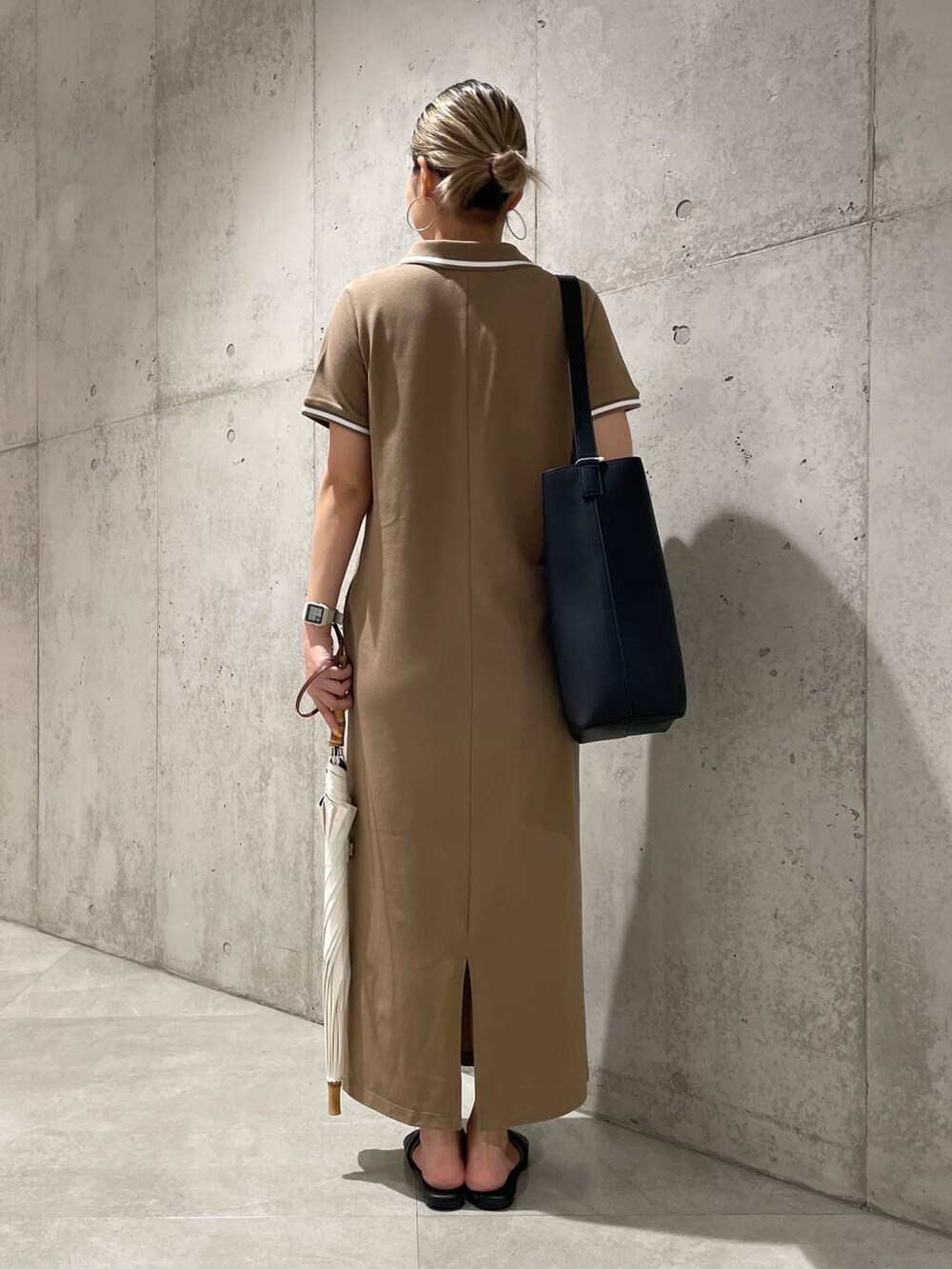 ブラック系のショルダーバッグ、ベージュ系のワンピース、ホワイト系の長傘を着用したレディースの夏コーディネートの4枚目の写真