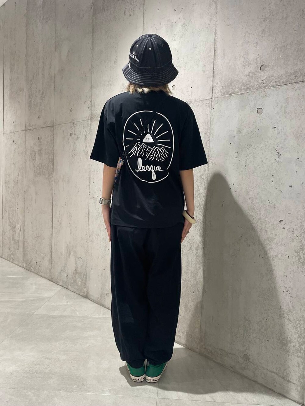 ブルー系のショルダーバッグ、ブラック系のTシャツ/カットソー、ブラック系のハットを着用したレディースの夏コーディネートの3枚目の写真