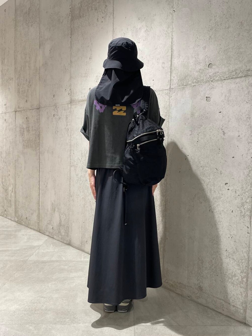 ブラック系のTシャツ/カットソー、ブラック系のバックパック/リュック、グレー系のスカートを着用したレディースの夏コーディネートの3枚目の写真