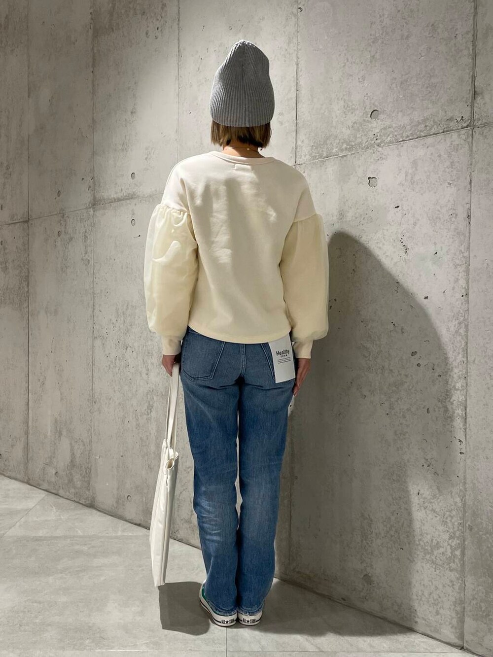 グリーン系のスニーカー、ホワイト系のトートバッグ、ホワイト系のスウェットを着用したレディースの冬コーディネートの3枚目の写真