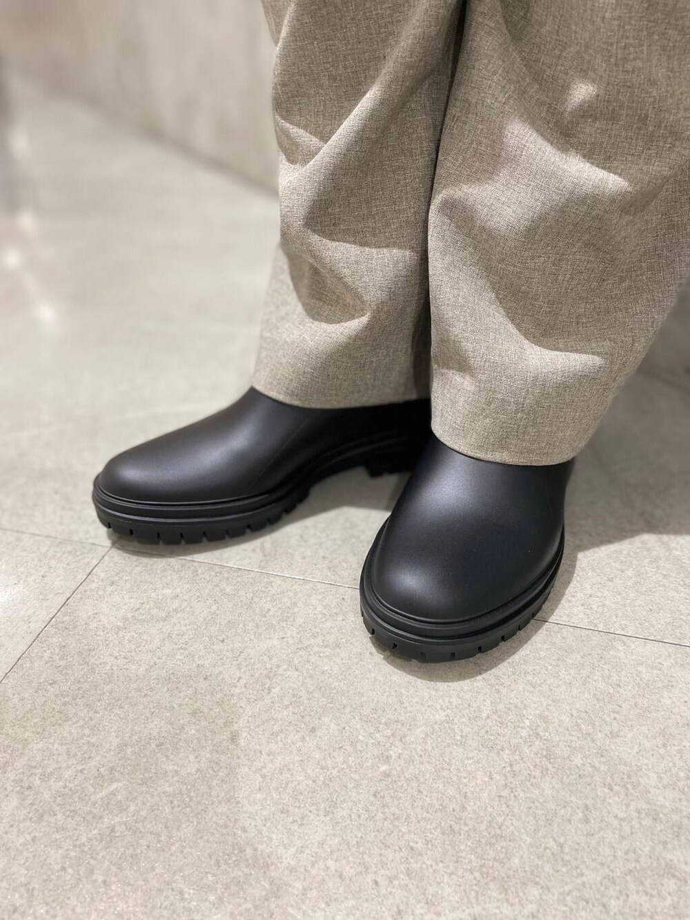 ベージュ系のその他パンツ、ベージュ系のシャツ/ブラウス、ブラック系のレインシューズを着用したレディースの夏コーディネートの4枚目の写真