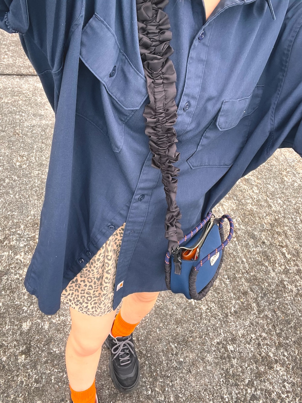 ブルー系のシャツ/ブラウス、ブラック系のスニーカー、ブルー系のショルダーバッグを着用したレディースの夏コーディネートの2枚目の写真