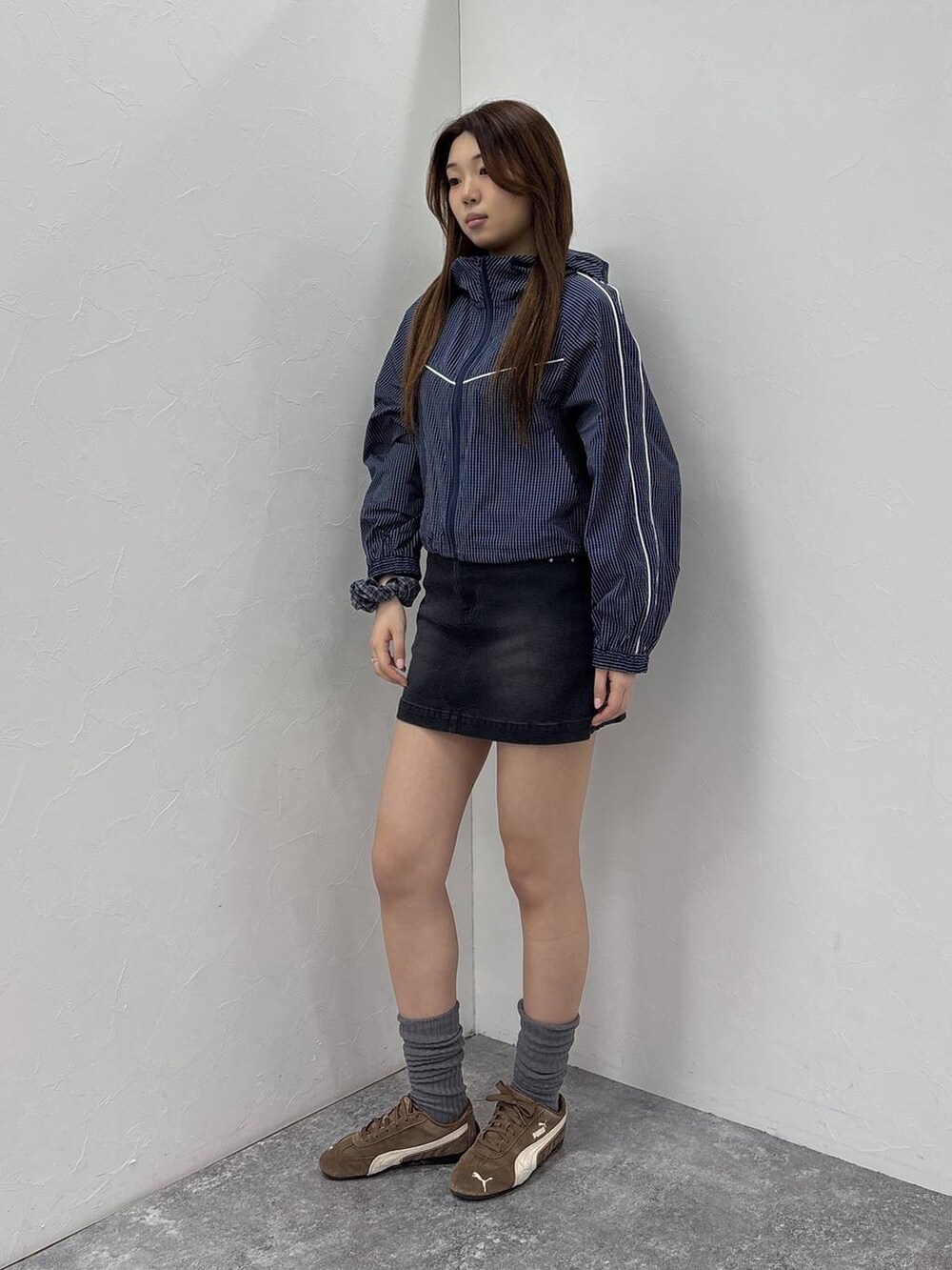 ブルー系のブルゾン、ブラック系のデニムスカートを着用したレディースの春コーディネートの4枚目の写真