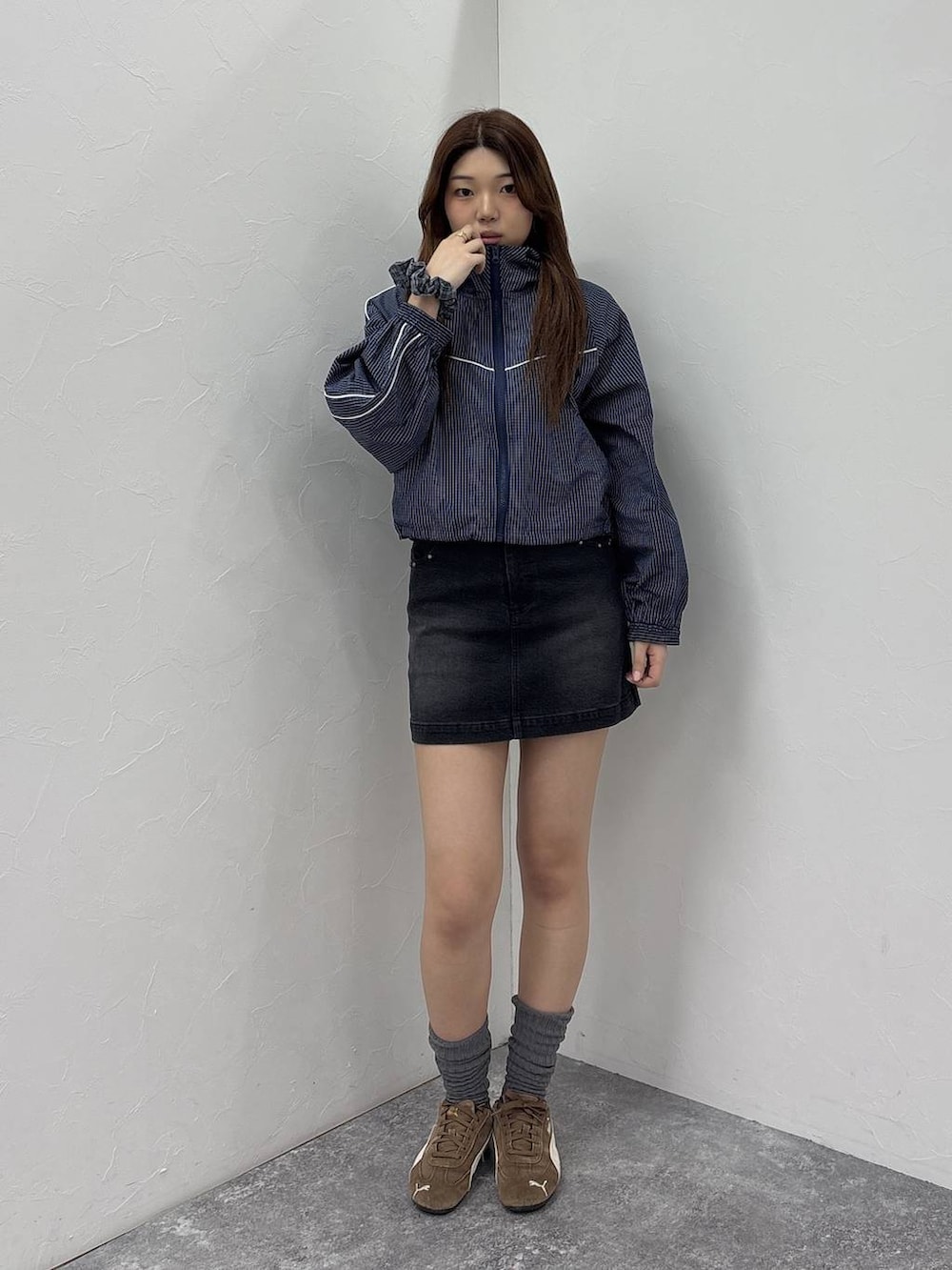 ブルー系のブルゾン、ブラック系のデニムスカートを着用したレディースの春コーディネートの3枚目の写真