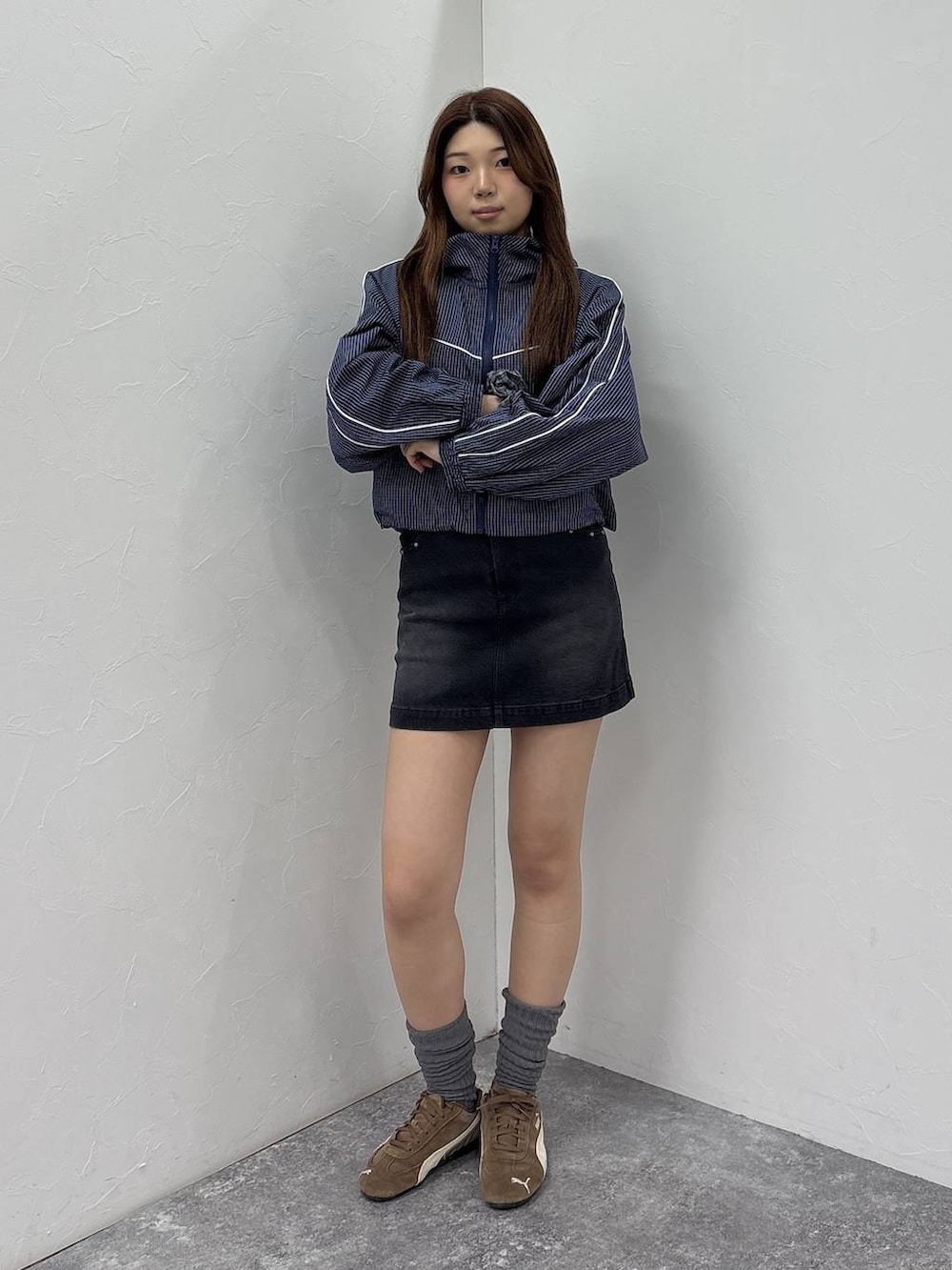 ブルー系のブルゾン、ブラック系のデニムスカートを着用したレディースの春コーディネートの2枚目の写真