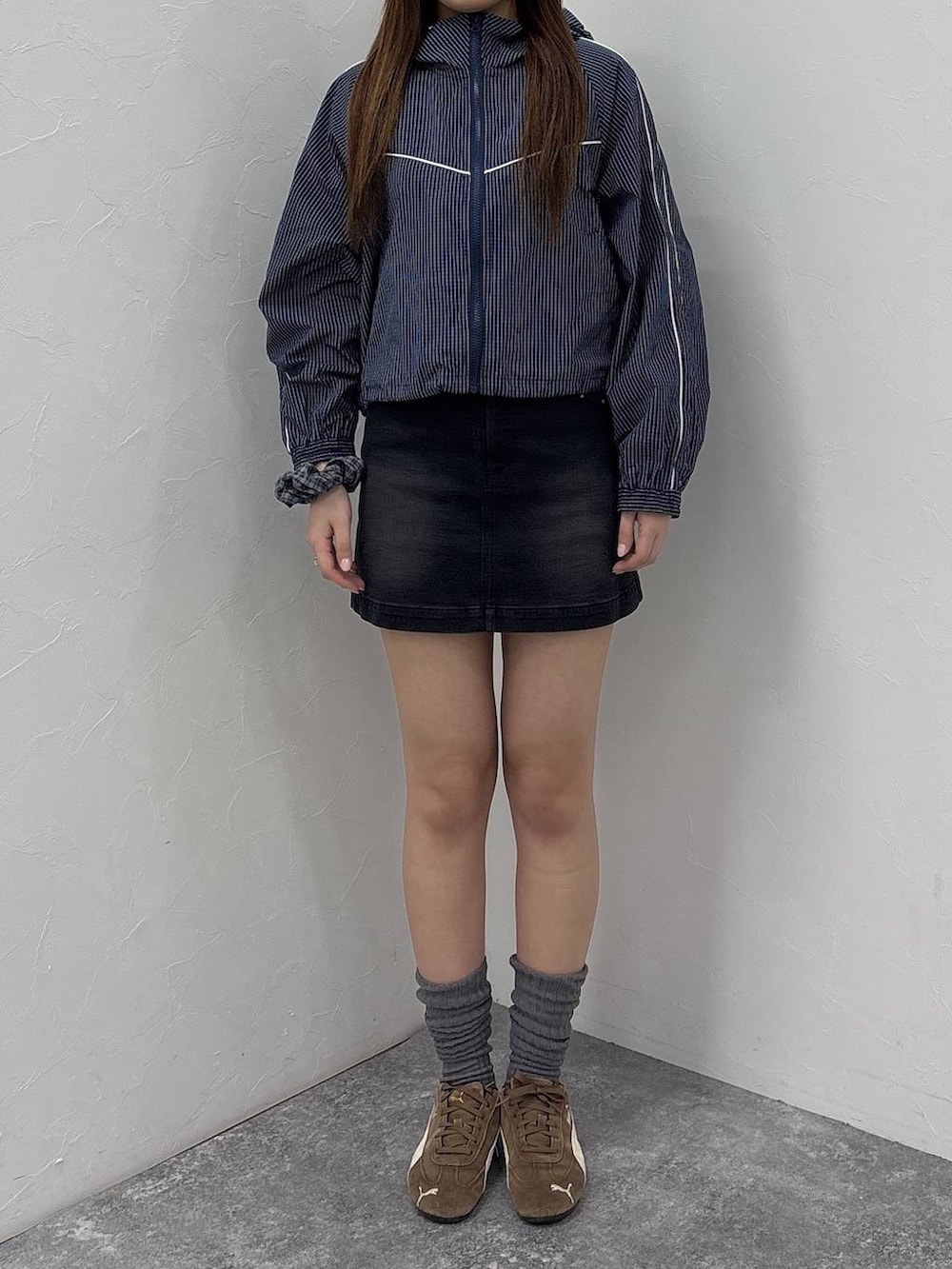 ブルー系のブルゾン、ブラック系のデニムスカートを着用したレディースの春コーディネートの7枚目の写真