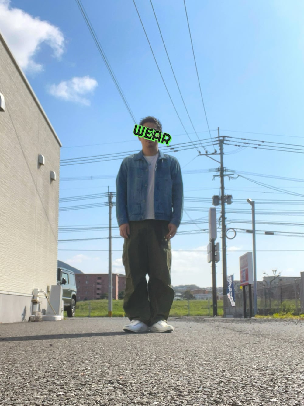 グリーン系のカーゴパンツ、ブラック系のショルダーバッグ、ホワイト系のスニーカーを着用したメンズの春コーディネートの2枚目の写真