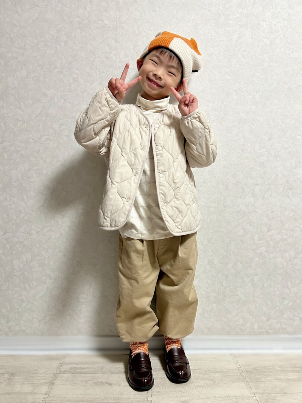 グレー系のTシャツ/カットソー、ホワイト系のノーカラージャケット、グリーン系のショルダーバッグを着用したキッズの秋コーディネートの4枚目の写真