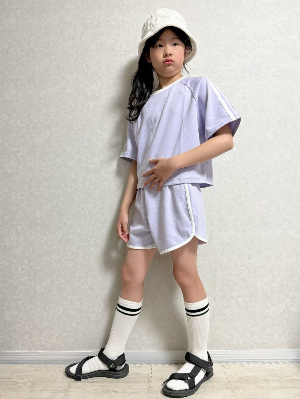 パープル系のTシャツ/カットソー、パープル系のスウェットパンツ、ブラック系のサンダルを着用したキッズの春コーディネートの2枚目の写真