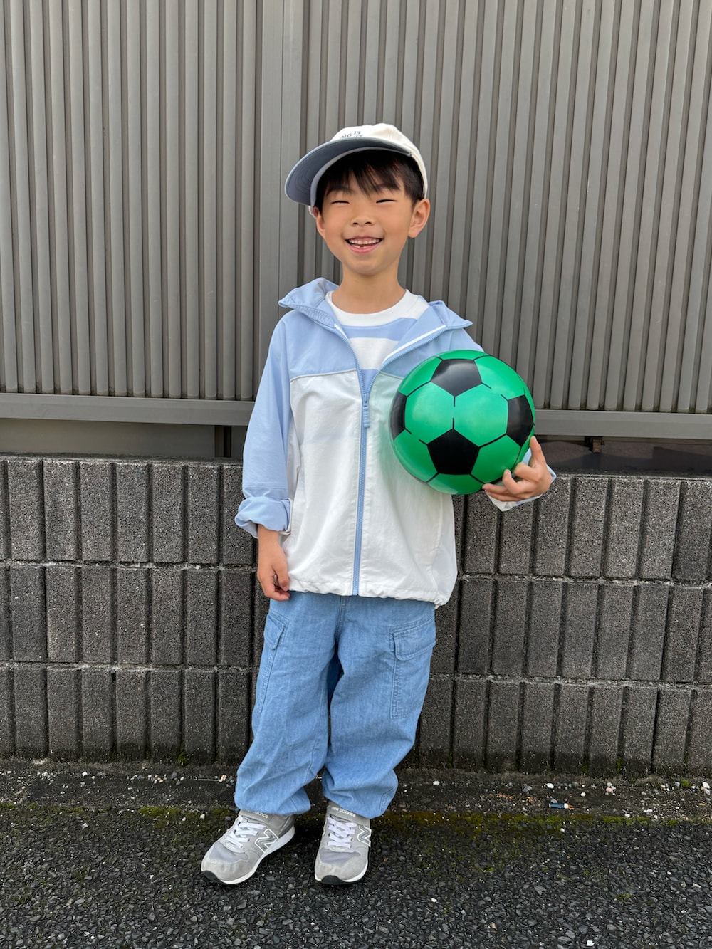 グリーン系のTシャツ/カットソー、ブルー系のナイロンジャケット、ブルー系のパンツを着用したキッズの春コーディネートの3枚目の写真