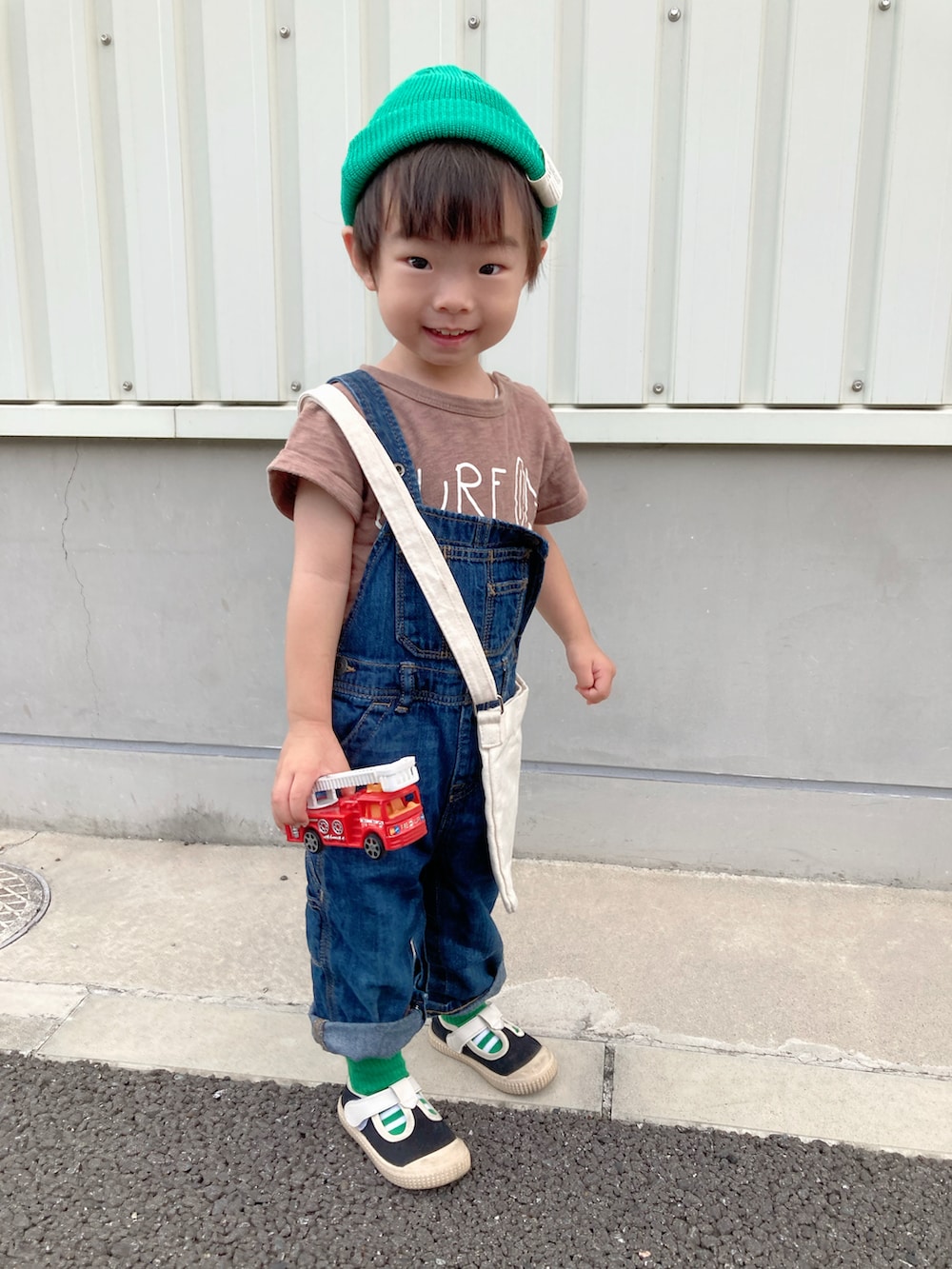 ブラウン系のTシャツ/カットソー、ブルー系のサロペット/オーバーオール、ホワイト系のショルダーバッグを着用したキッズの夏コーディネートの5枚目の写真