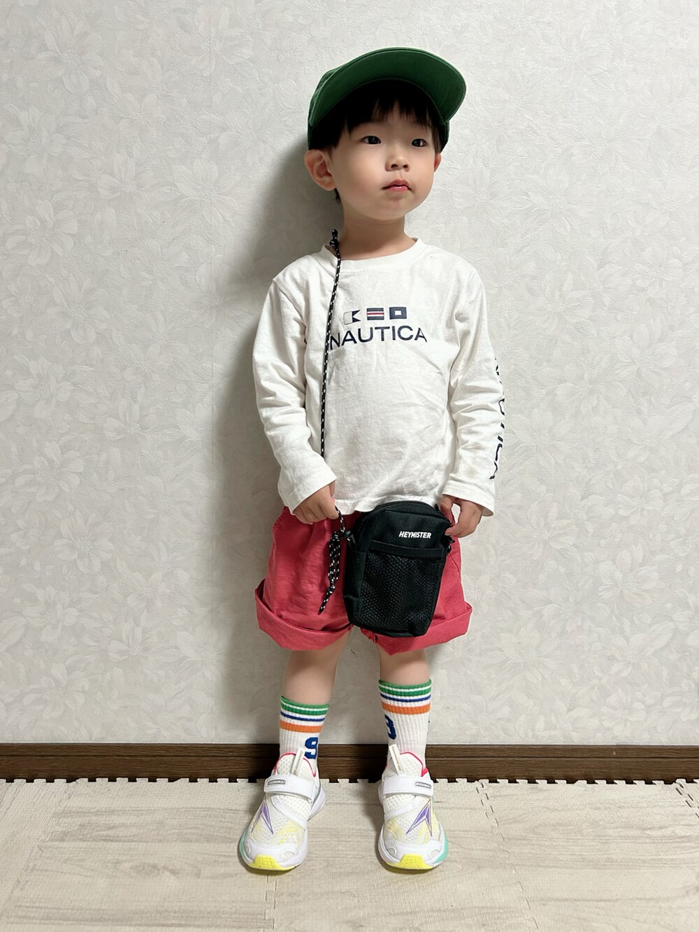 ホワイト系のTシャツ/カットソー、レッド系のパンツ、ブラック系のショルダーバッグを着用したキッズの春コーディネートの2枚目の写真