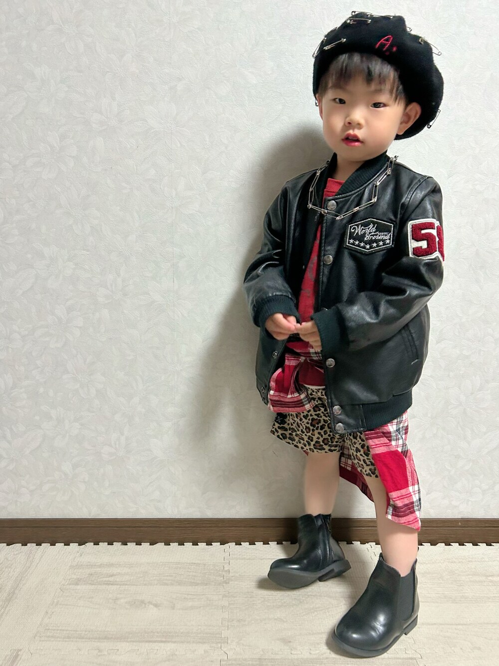 レッド系のTシャツ/カットソー、レッド系のシャツ/ブラウス、ブラック系のライダースジャケットを着用したキッズの春コーディネートの2枚目の写真