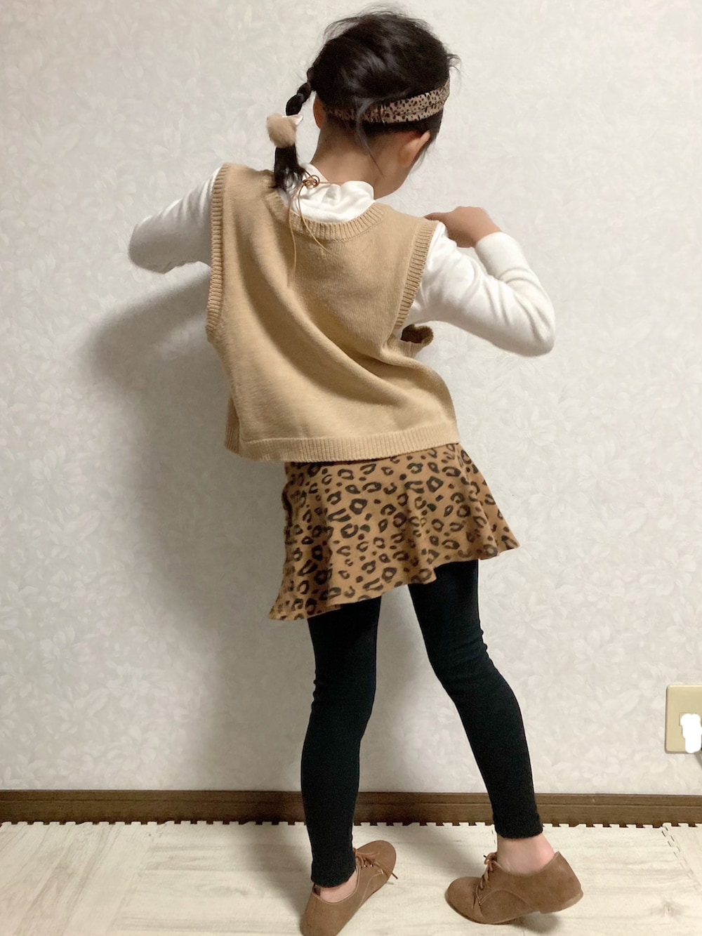 ホワイト系のTシャツ/カットソー、ベージュ系のベスト、ブラウン系のスカートを着用したキッズの秋コーディネートの5枚目の写真