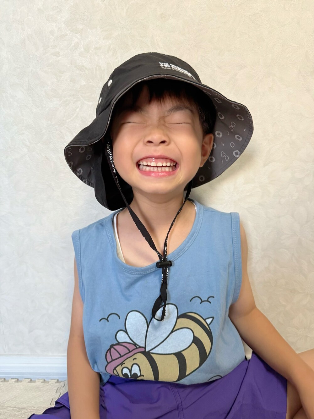 パープル系のカーゴパンツ、ブラック系のサンダル、ブルー系のタンクトップを着用したキッズの夏コーディネートの3枚目の写真