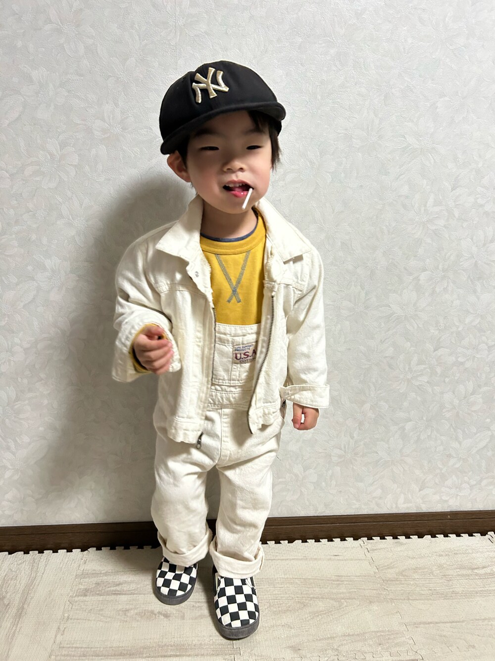 イエロー系のスウェット、ホワイト系のデニムジャケット、ホワイト系のサロペット/オーバーオールを着用したキッズの冬コーディネートの2枚目の写真