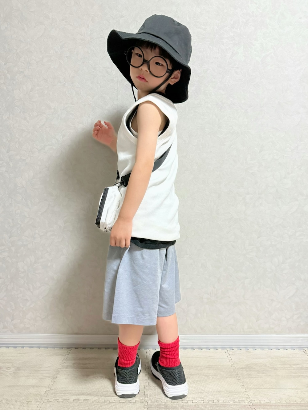 グレー系のパンツ、ブラック系のサンダル、ホワイト系のタンクトップを着用したキッズの夏コーディネートの2枚目の写真