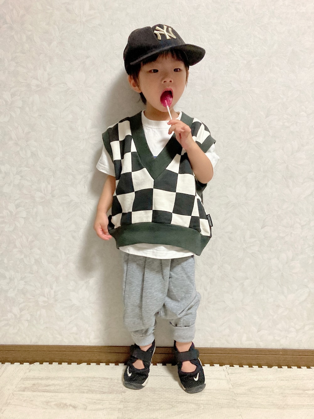 ホワイト系のTシャツ/カットソー、ブラック系のベスト、グレー系のスウェットパンツを着用したキッズの秋コーディネートの4枚目の写真