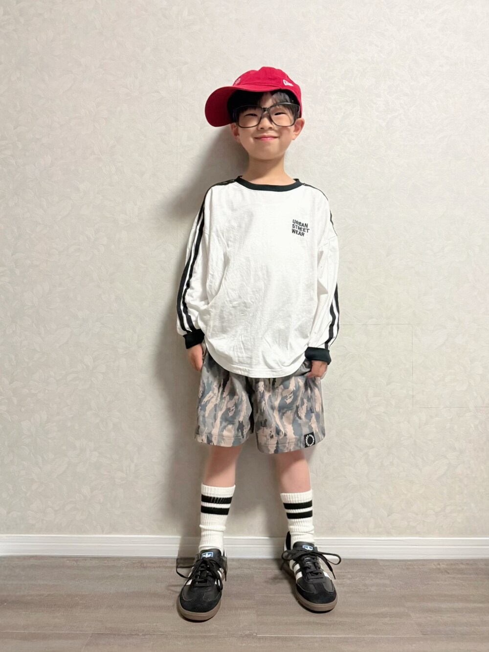 ブラック系のショルダーバッグ、ブラック系のスニーカー、ホワイト系のTシャツ/カットソーを着用したキッズの春コーディネートの3枚目の写真