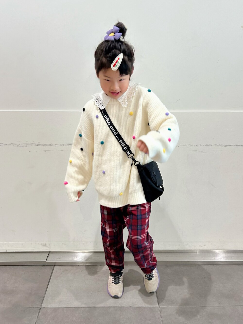 ホワイト系のニット/セーター、ホワイト系のシャツ/ブラウス、ブラック系のショルダーバッグを着用したキッズの冬コーディネートの2枚目の写真