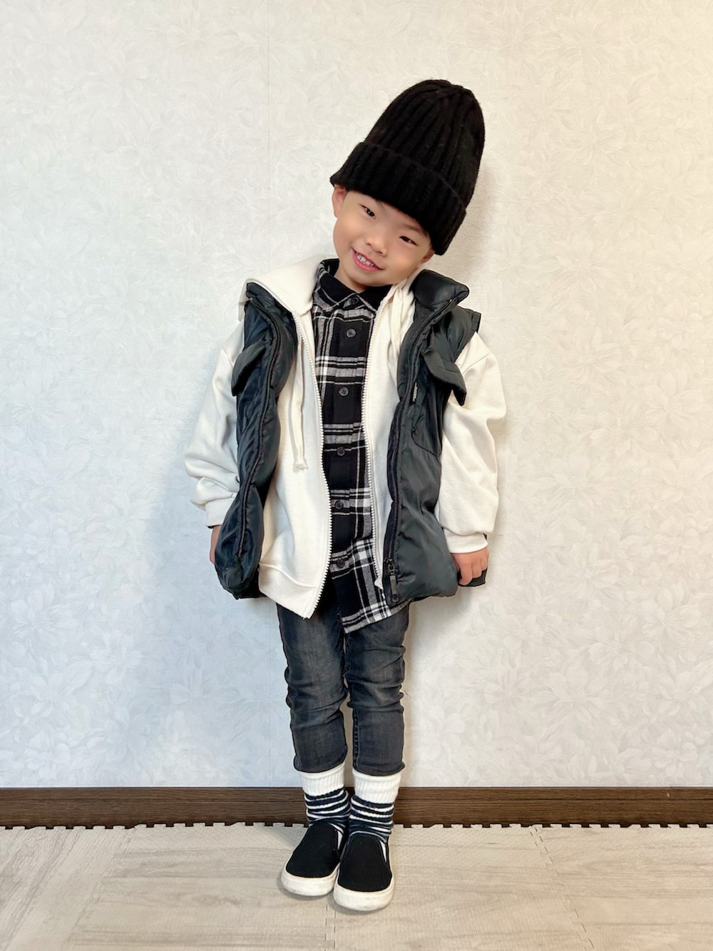 ブラック系のシャツ/ブラウス、ホワイト系のパーカー、ブラック系のダウンベストを着用したキッズの秋コーディネートの2枚目の写真