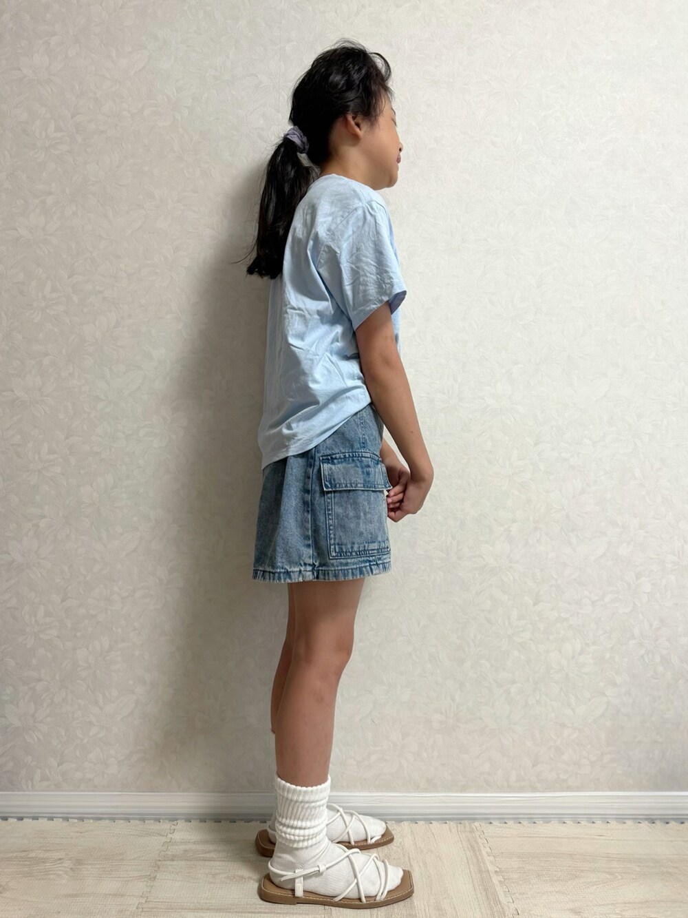 ブルー系のTシャツ/カットソー、ブルー系のデニムスカート、ブラック系のサンダルを着用したキッズの夏コーディネートの3枚目の写真