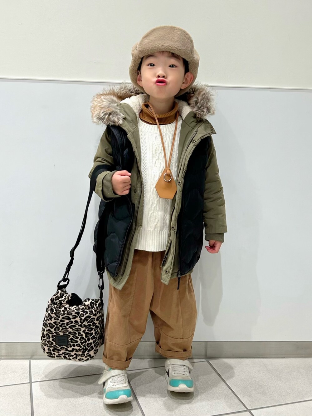 イエロー系のニット/セーター、ホワイト系のニット/セーター、グリーン系のモッズコートを着用したキッズの冬コーディネートの2枚目の写真